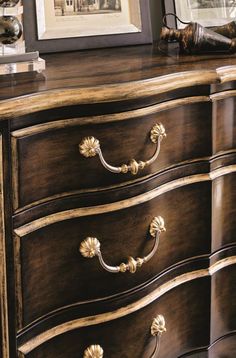 an ornate dresser with gold handles and knobs on it's drawers is shown