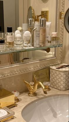 a bathroom sink with gold faucet, mirror and soap dispenser