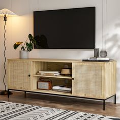 an entertainment center with a flat screen tv mounted on it's sideboard in a living room