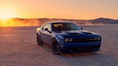 a blue sports car parked in the middle of desert at sunset with dust blowing behind it