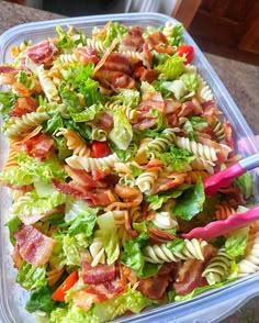 a plastic container filled with pasta salad and bacon