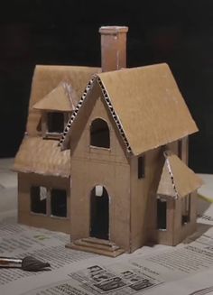 a model house sitting on top of a table next to a pen and paper towel