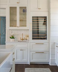 a kitchen with white cabinets and gold trim on the doors, counter tops and drawers