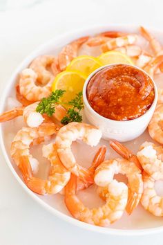 a white plate topped with shrimp and dipping sauce