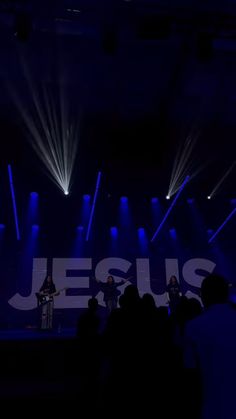 a group of people standing on top of a stage in front of bright blue lights