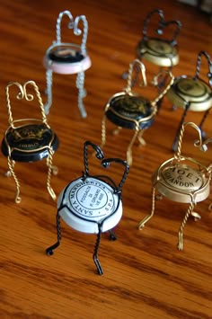 several miniature chairs and stools sitting on a wooden table with metal cords attached to them