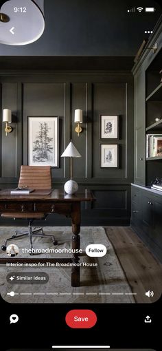 a home office with black walls and wooden flooring, along with bookshelves