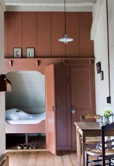 a bunk bed in the corner of a room with wooden flooring and pink walls