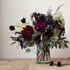 a vase filled with lots of flowers on top of a table