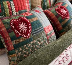 the pillows are decorated with red and green designs on them, along with snowflakes