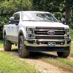 a white truck driving down a dirt road