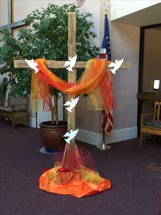 the cross is decorated with orange and white sheers, which are draped over it