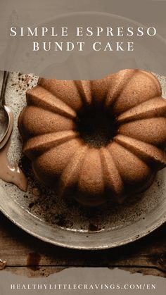 a bundt cake sitting on top of a plate next to a knife and spoon