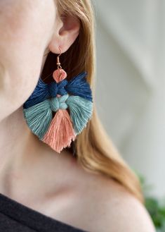 a woman wearing large earrings with tassels