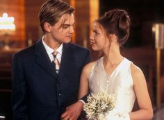 a young man and woman standing next to each other in front of a church alter