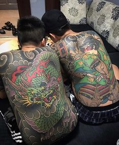 two people with tattoos on their backs