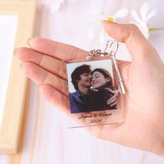 a person holding a keychain with a photo on it