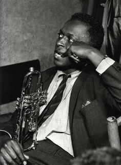 a black and white photo of a man holding a trumpet