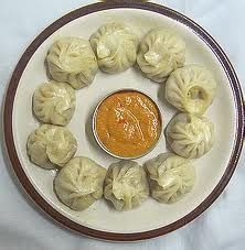 some dumplings on a plate with sauce in the middle