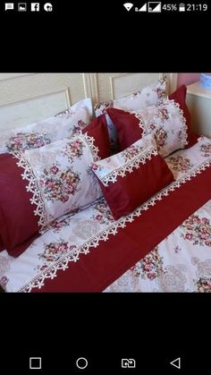 a bed with red and white sheets and pillows