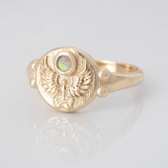 The Quetzal is a phoenix-like South American bird,  sacred to ancient Mayas and Aztecs. Known as a symbol of freedom, goodness and light, it was believed that it preferred to die of hunger rather than to live as a prisoner. This ring is adorned with a genuine opal to reflect the magnificent colors of its beautiful feathers.  The Gold Phoenix Ring with Opal Gemstone is a striking symbol of rebirth, resilience, and eternal beauty.  The phoenix, a legendary creature known for rising from its own as Phoenix Ring, Beautiful Feathers, Symbol Of Freedom, October Birthstone Ring, Ancient Maya, Celestial Ring, Eternal Beauty, October Birthstone Rings, Vintage Bee