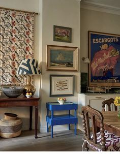 a dining room filled with furniture and pictures on the wall