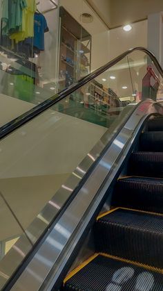 an escalator in a shopping mall with people walking up and down the stairs