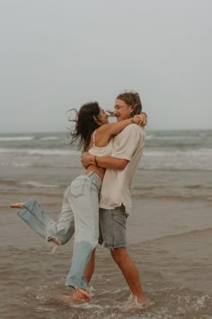 two people are hugging in the water at the beach