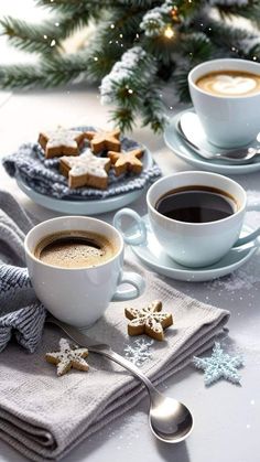 two cups of cappuccino and some cookies on a table with christmas decorations