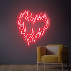 a heart shaped neon sign in the corner of a room with a chair next to it