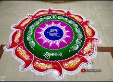 a colorful rangdi design on the floor in front of a building with words written in it