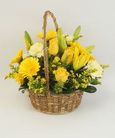 a basket filled with yellow and white flowers