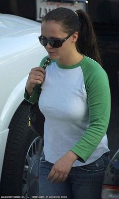 a woman with sunglasses is standing next to a white car