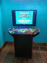 a video game machine sitting on top of a wooden floor next to a blue wall