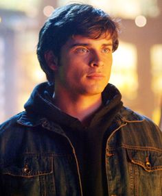 a young man in a denim jacket looking at the camera with an intense look on his face