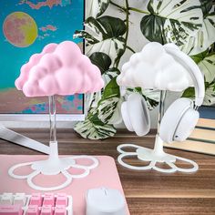 there is a pink and white cloud on the desk with headphones in front of it