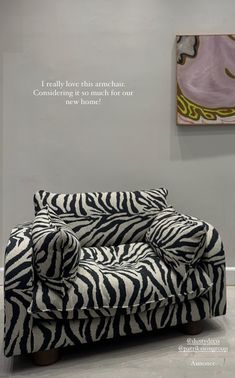 a zebra print couch sitting in front of a wall with a quote about love on it