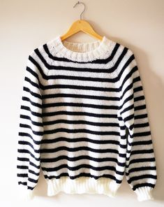 a black and white striped sweater hanging on a hanger