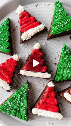 christmas cookies decorated with green and red icing on a white plate in the shape of trees