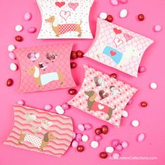 some pink and white pillows on a pink surface with candy sprinkles around them