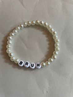 "\"BRUH\" - White artificial pearl bead, stretchy bracelet with acrylic letters * Hand-made using artificial pearl beads, 4x7mm white round acrylic alphabet beads and 0.8mm elastic string * Beautifully packaged in a sheer white drawstring organza bag" Beads Letters Bracelet, Round Beads Bracelet, Bead Word Bracelet Ideas, Alphabet Beads Ideas, Diy Pearl Bracelet Ideas, Bead Bracelet Ideas Words, Letter Bracelet Beads Ideas Funny, Letter Beads Ideas