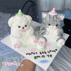 two cakes shaped like cats sitting on top of a table