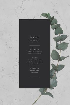 a black menu card with eucalyptus leaves on it