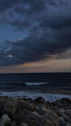 the sky is dark and cloudy over the ocean