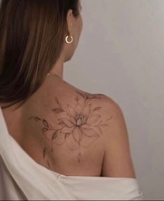 a woman with a flower tattoo on her back shoulder