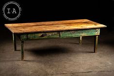 an old wooden table sitting in the middle of a dark room with a logo above it