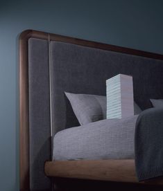 a bed that has some pillows on it and a block in the middle of the headboard