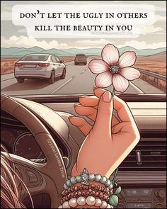 a hand holding a flower in front of a steering wheel on a road with cars behind it