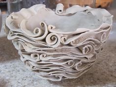 a white bowl sitting on top of a table covered in lots of different shapes and sizes