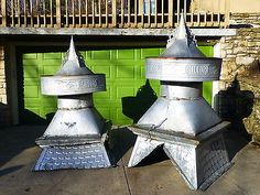 two metal fire hydrants sitting in front of a green garage door